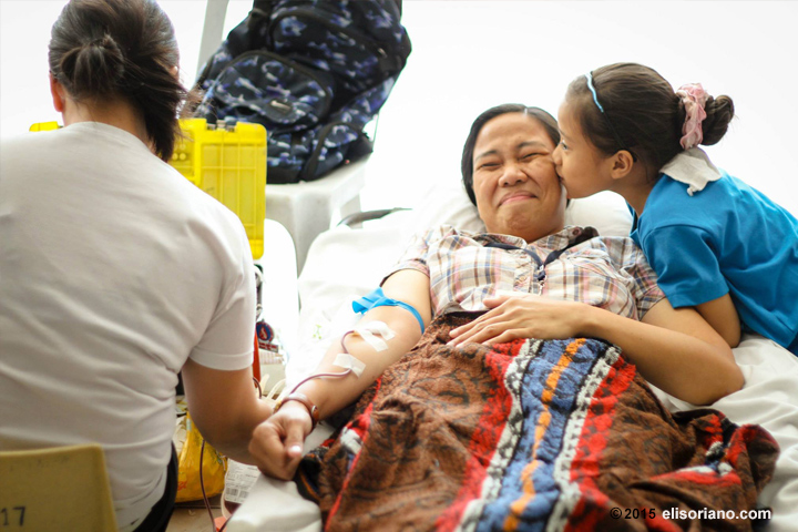 A member of the Church of God International is kissed by her daughter as she donates her blood in MCGI's blood donation drive at the ADD Convention Center in Pampanga, Philippines.